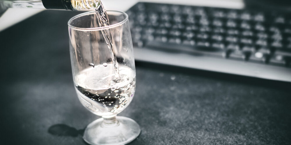 Drunk,At,Work.,Pouring,A,Glass,Of,Vodka.,Defocused,Office Alcohol at work showing functional alcoholism