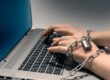 Individual Shackled to a laptop to show online gambling addiction